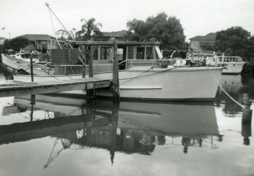 Black and white photograph of timber launches moored at the family jetty