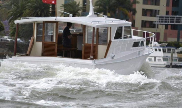 Classic timber windowed cruiser underway on the river