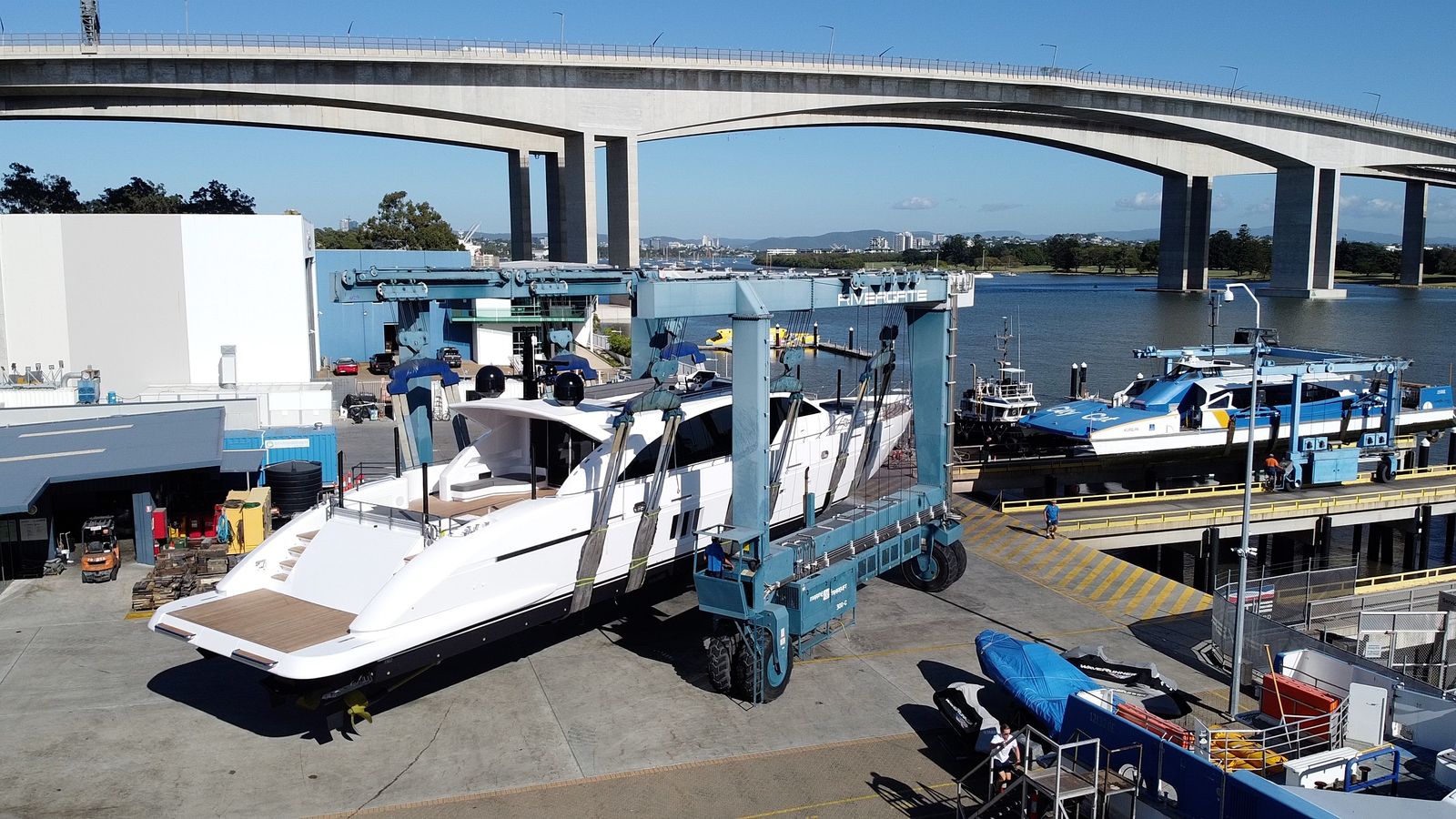Superyacht in the travel lift slings at the shipyard, ready for launch
